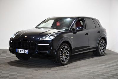 Une Porsche Cayenne noire est garée sur un sol à damier.