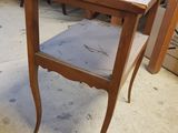 a small table with a shelf on it in a room