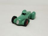 a green toy car that is sitting on a white surface