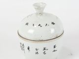 a white bowl with writing on it sitting on a white surface