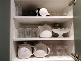 a cabinet with a lot of dishes and cups on it