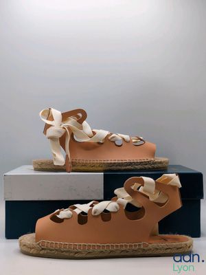 pair of women ' s tan leather sandals with laces on them