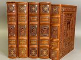 trois livres sont alignés sur une surface blanche