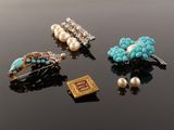 three pairs of turquoise, white and gold brooches on a black surface