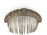 a gold comb that is sitting on a white surface