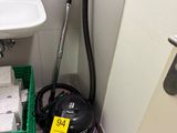 un aspirateur et un lavabo dans une petite salle de bains