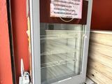 une porte vitrée sur laquelle est accrochée une affiche, dans un magasin
