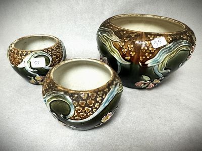 trois vases posés sur une table, sur lesquels est accrochée une étiquette