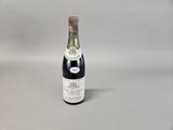 bottle of wine on a white surface with a gray background
