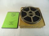 une bobine de film posée dans une boîte à côté d'un DVD