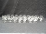 twelve wine glasses lined up in a row on a black background