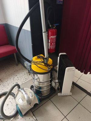 un aspirateur posé sur le sol à côté d'un radiateur