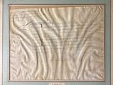 an old document with writing on it is hanging on a wall