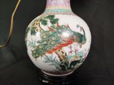 a white vase with a peacock on it on a table
