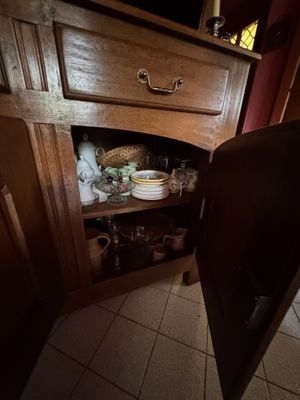 un placard dans la cuisine sur lequel sont posés de la vaisselle et des tasses