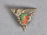 une image représentant un triangle argenté orné d'un emblème vert et rouge
