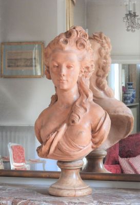 a bust of a woman sitting on a table in front of a mirror