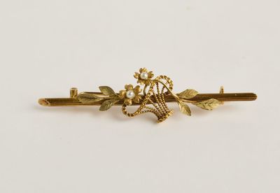 un gros plan sur une barrette plaquée or ornée de fleurs et de feuilles