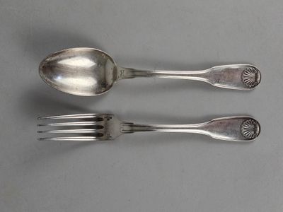 two silver spoons and a fork on a table