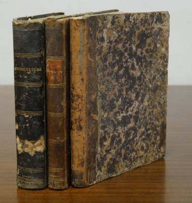 two old books sitting on top of a wooden table next to each other