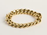 une image d'un bracelet en or sur fond blanc