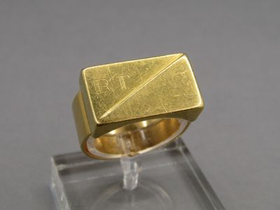 une photo d'une bague en or posée sur le dessus d'une vitrine transparente