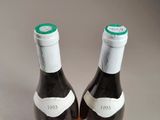 two bottles of wine sitting on top of a table next to each other