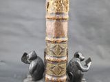 un vieux livre posé sur une table, à côté d'une statue représentant un chien