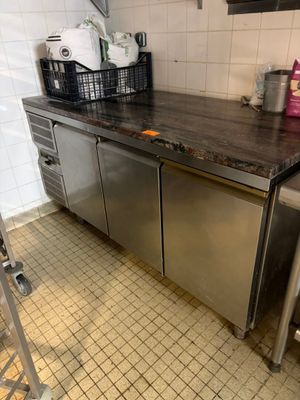 une cuisine équipée d'un plan de travail en inox et d'un lave-vaisselle