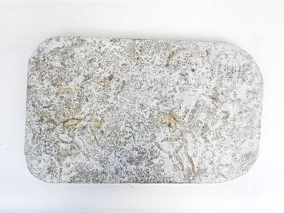 a stone with a design on it sitting on a white surface