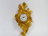 une horloge dorée accrochée au mur sur fond blanc