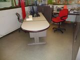 un bureau avec un ordinateur et une chaise rouge dans un coin