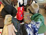 many hats and gloves sitting on a table in a room