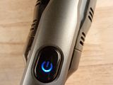 a close up of a cordless hair dryer on a wooden surface
