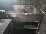 un évier en acier inoxydable dans le coin d'une salle de bains