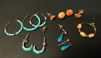 several pairs of earrings and bracelets are sitting on a table
