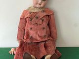 a doll that is sitting on a green surface