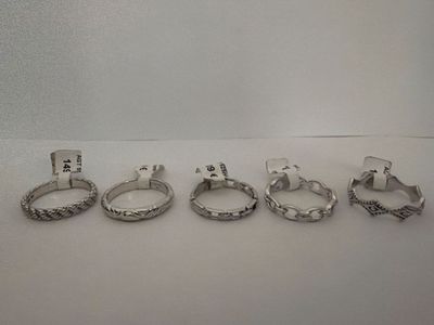 five different rings are arranged in a row on a white surface