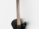 a black guitar that is sitting on a white surface