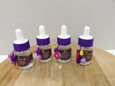 three bottles of liquid sitting on top of a wooden table