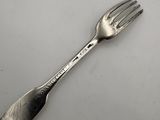 silver plated fork on a white table with a white background