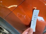 a person holding a ruler in front of a car