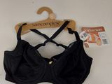 black bralette on a wooden hanger with a tag on it