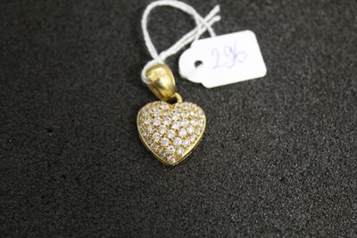 un pendentif en or en forme de cœur, serti de diamants, sur un fond noir