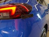 a close up of a blue car with its tail lights on