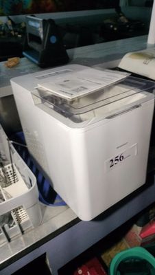 a white machine sitting on top of a counter next to other appliances