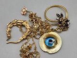 a gold necklace with a blue eye and a gold ring