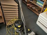 un aspirateur posé sur le sol d'une pièce