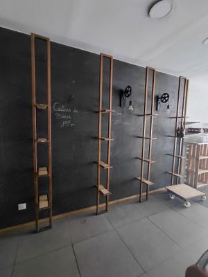 une pièce avec un tableau noir accroché au mur et des étagères