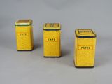 three small yellow tins with yellow labels on them sitting next to each other